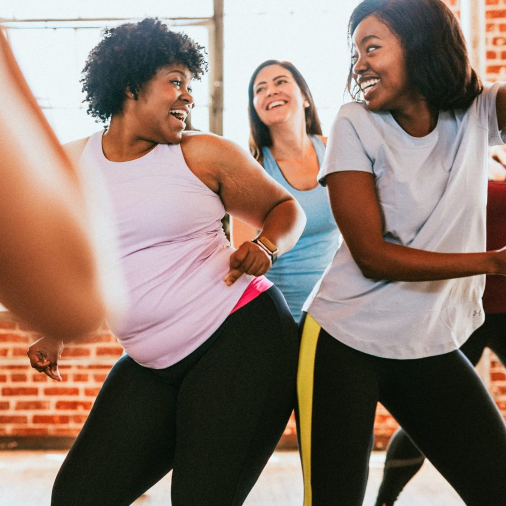 happy smiling group of women dancing or exercising together