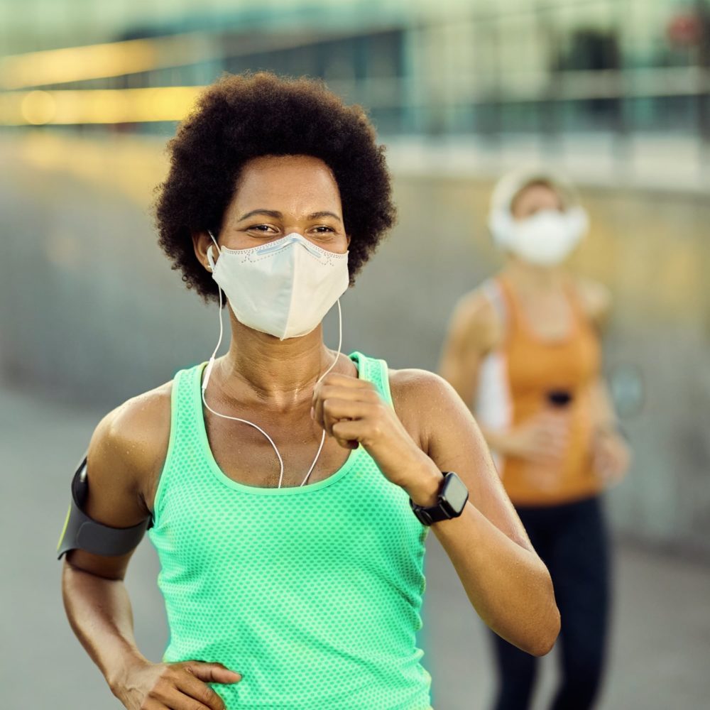 African American woman in mask running physical activity